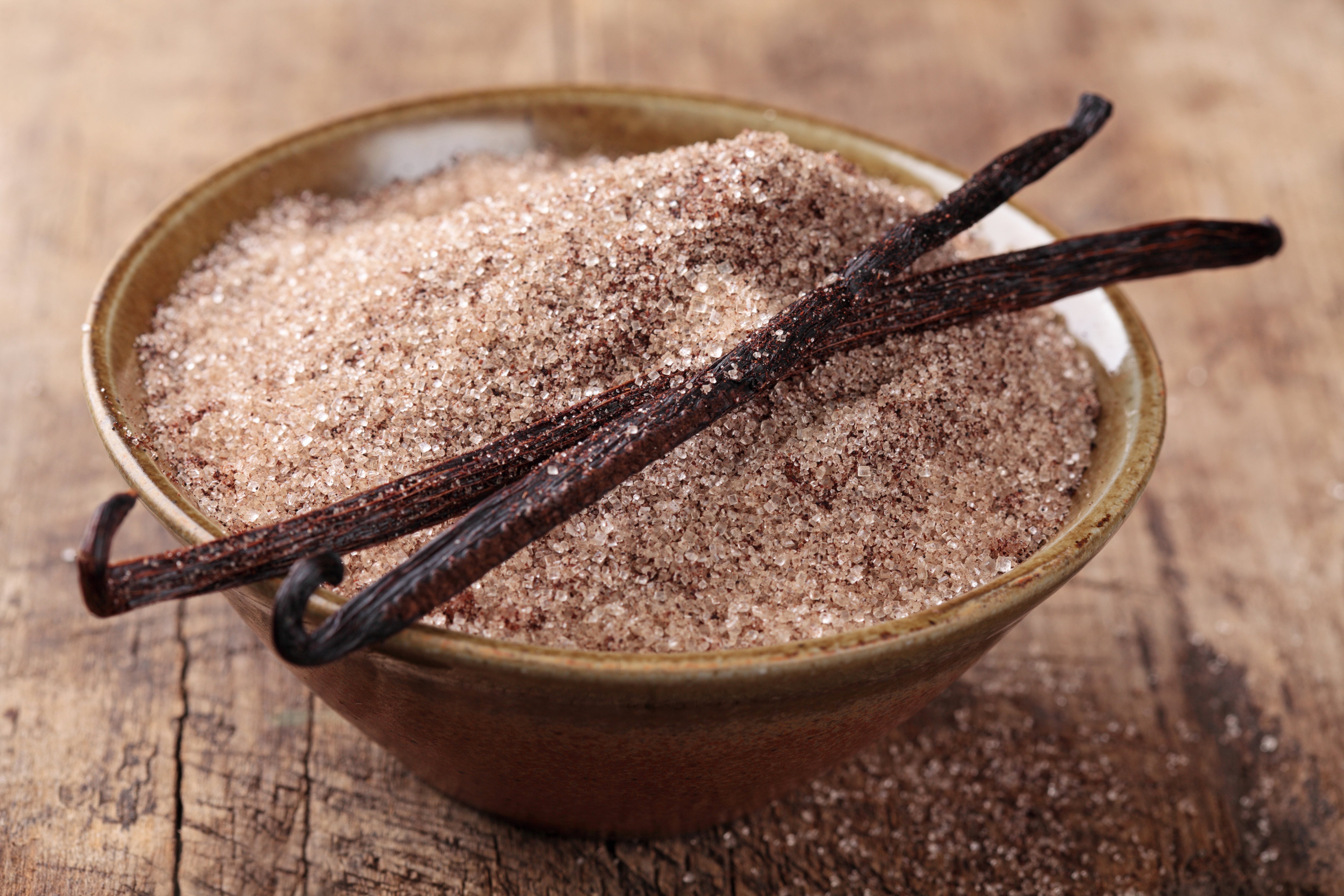 vanilla bean sugar in bowl with vanilla beans