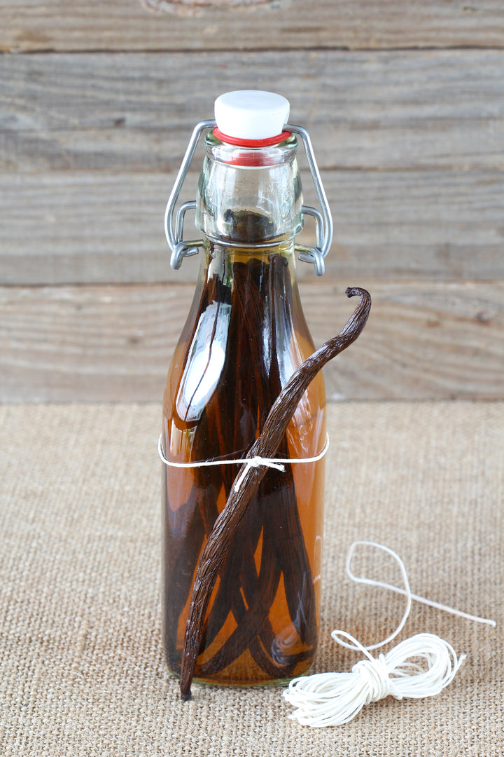 single vanilla beans tied to bottle with beans inside