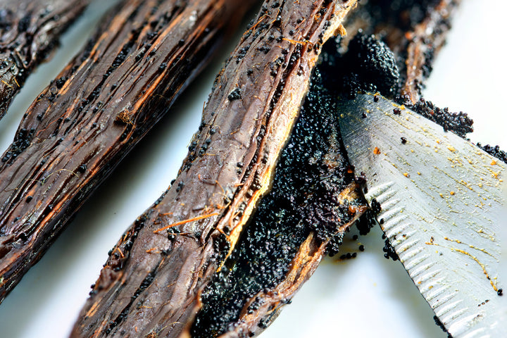 closeup of split vanilla bean with knife