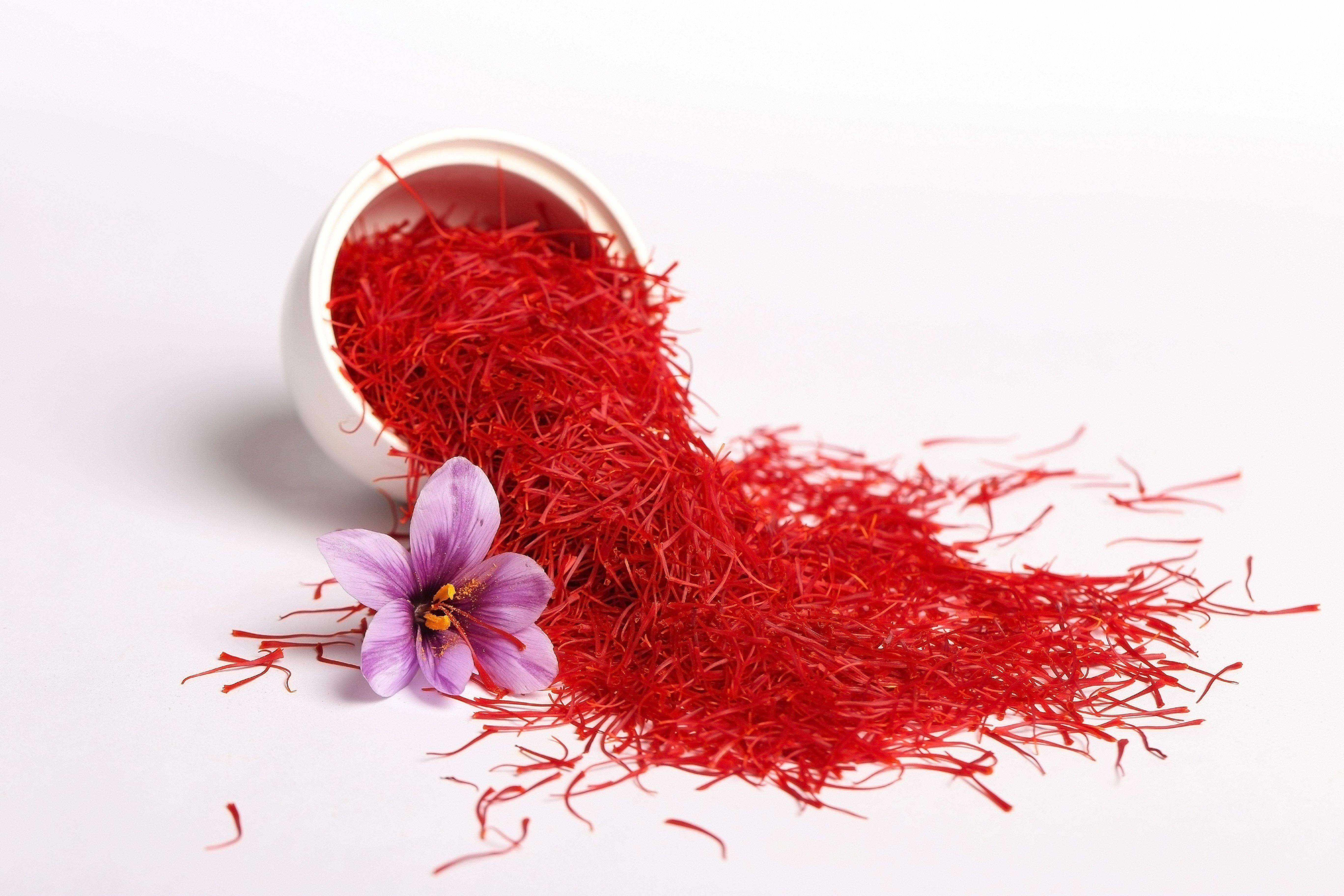 saffron spilling out of white bowl with flower