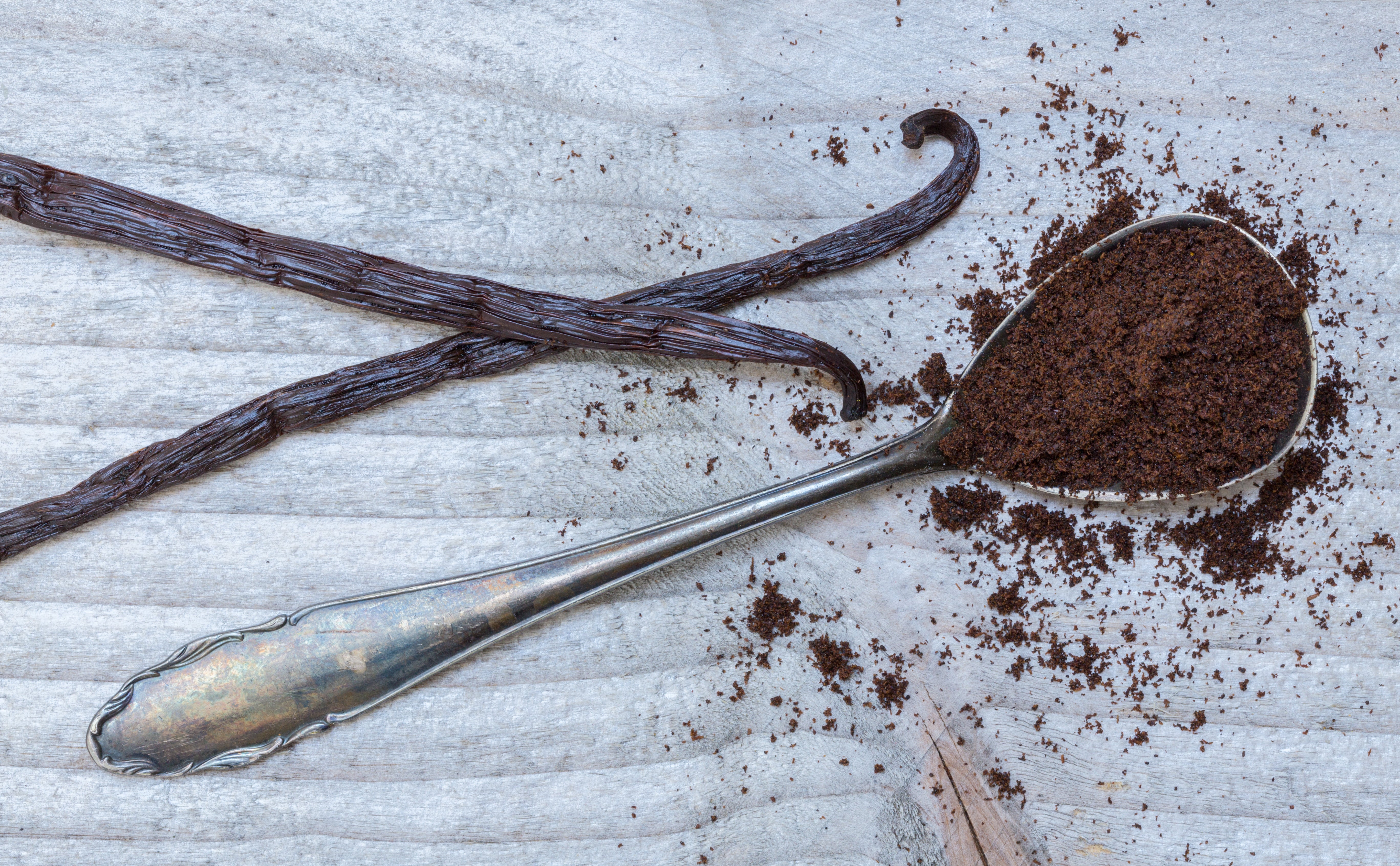 vanilla bean powder on table with silver table spoon